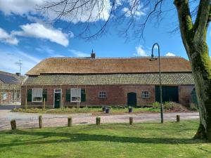 an old brick building with a tree and a street light at Boerderij Beddengoed in Veldhoven +12 photos