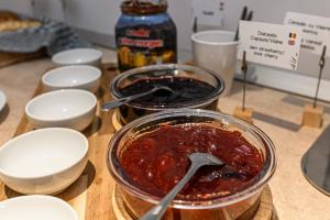 a glass bowl of jam on a wooden table at Johann Strauss Hotel in Bucharest