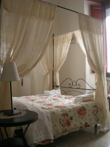 una camera da letto con un letto con copriletto e tende floreali di Ascoli Antica B&B ad Ascoli Piceno