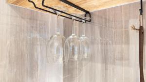 a group of wine glasses hanging from a wall at The Yata Kominka 谷田 in Shiroi +87 photos