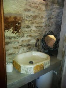 フランカヴィッラ・フォンターナにあるTrullallàの石壁のバスルーム(石の洗面台付)