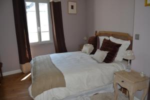 a bedroom with a large bed and a window at Caboteurs in Le Pouliguen