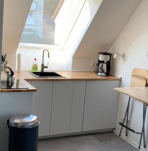 a kitchen with a counter with a sink and a window at Moderne Ferienwohnung in Berlin Lichtenrade in Berlin +7 photos