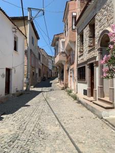 a cobblestone street in a town with buildings at Urbana - Ayvalık in Ayvalık