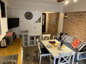 a living room with a table and a kitchen with a clock at Urbana - Ayvalık in Ayvalık