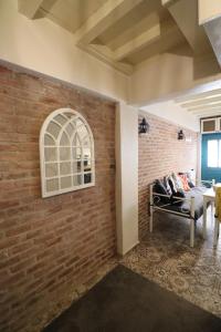 a brick wall with a window and a couch in a room at Urbana - Ayvalık in Ayvalık