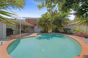 een groot zwembad in het midden van een tuin bij Santai Sands - Bribie Island 4BD Home in Woorim