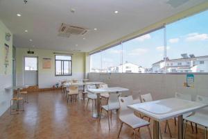 a classroom with tables and chairs and a large window at 7 Days Inn Suzhou Wangting Pearl Commercial Plaza in Suzhou