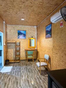 Cette chambre dispose d'une table, de chaises et d'un bureau. dans l'établissement Lak Kao Nai Resort หลักเก้า ไนท์ รีสอร์ท, à Ban Pha Saeng Lang