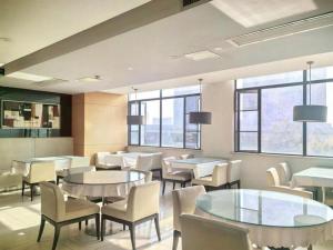 a restaurant with tables and chairs and windows at Jinjiang Inn Wuhan Wujiashan Development District Branch in Wuhan