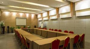 a conference room with tables and chairs and a screen at Jinjiang Inn Dalian North Railway Station in Dalian