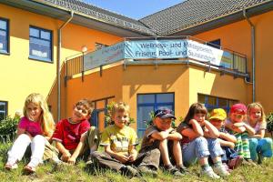 a group of children sitting in front of a building at Holiday home in Markkleeberg near a lake in Markkleeberg