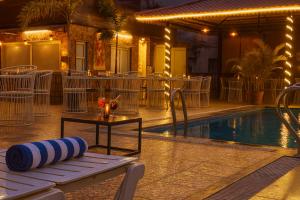 ウダイプールにあるHotel Grand Bhagwat with rooftop swimming poolのプールサイドのスイミングプール(テーブル、椅子付)