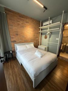 Kampong TangihanにあるTF Luxe Suites K Avenue Kepayanのレンガの壁のベッドルーム1室(白い大型ベッド1台付) +22枚の写真