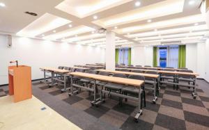 an empty lecture room with desks and chairs at 7Days Premium Chongqing Jiangbei International Airport Rongchuang in Chongqing