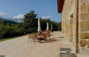 a patio with tables and chairs with umbrellas at Solatsu Baserria - Apartamentos Rurales in Elorrio