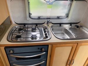 eine Küche mit Herd und Spüle in der Unterkunft Beside the Seaside in Whangamata