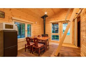 ein Esszimmer mit Tisch und Kühlschrank in der Unterkunft FARM SIDE - Vacation STAY 24170v in Tsumagoi