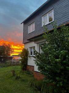 a house with a sunset in the background at Ferienwohnung am Rennsteig in Neuhaus am Rennweg