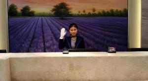 a woman is sitting at a desk with a computer at Lavande Hotel Changsha High-Speed Railway Station Shumuling Metro Station in Changsha