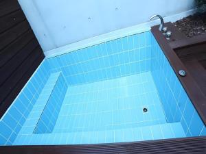 a blue tiled bath tub with a wooden deck at Crossing Hotel in Seoul