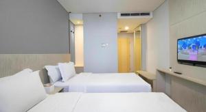 a hotel room with two beds and a flat screen tv at MIC Residence in Yogyakarta +86 photos
