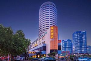a tall building with cars parked in front of it at Hongqiao Pujue International Zhongshan Park Metro Station in Shanghai