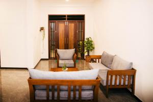 a living room with two chairs and a table at Cinnamon Forest Villa - Private Luxury Villa in Hikkaduwa in Hikkaduwa