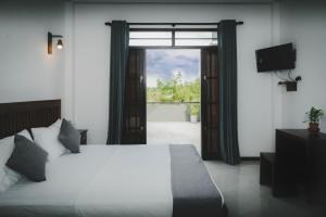 a bedroom with a bed and a door to a balcony at Cinnamon Forest Villa - Private Luxury Villa in Hikkaduwa in Hikkaduwa +38 photos