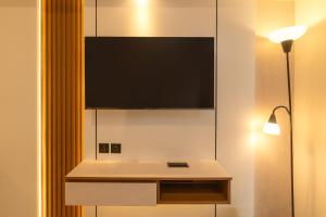 a flat screen tv on a wall in a room at Tokyo Riverside Apartemen PIK 2- Kaito Inn Royale in Muara
