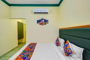 a bedroom with a bed with a head board at FabHotel Ranjit Residency in Hyderabad