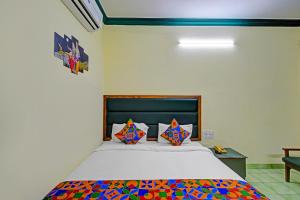a bedroom with a large bed with colorful pillows at FabHotel Ranjit Residency in Hyderabad