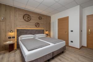 a bedroom with a large white bed and wooden walls at Hotel Pejo in Peio Fonti +64 photos