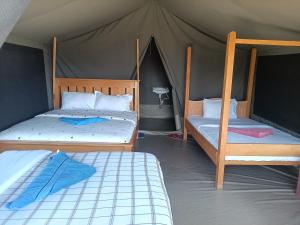 a bedroom with two beds and a tent at Semadep Village Guest House in Sekenani