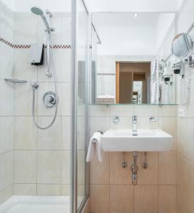 ein Badezimmer mit Waschbecken und Dusche in der Unterkunft Hotel Post Wrann in Velden am Wörthersee