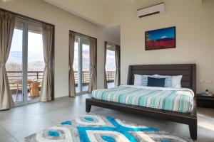 une chambre avec un lit et un balcon dans l'établissement Eden Glade - Khopoli - Mountain-view villa with Private pool, Spacious decks & Indoor activities, à Khopoli