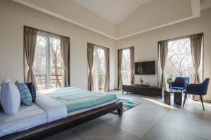 une chambre avec un lit, un bureau et des fenêtres dans l'établissement Eden Glade - Khopoli - Mountain-view villa with Private pool, Spacious decks & Indoor activities, à Khopoli 23 autres photos