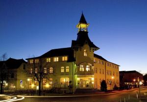 a large building with a clock tower on top of it at Hotel Dünenschloss mit Private Spa in Zinnowitz