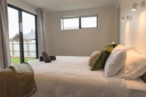 a bedroom with a large white bed with a window at A newly built 3 bedroom home in Methven