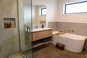 a bathroom with a tub and a sink and a shower at A newly built 3 bedroom home in Methven +19 photos