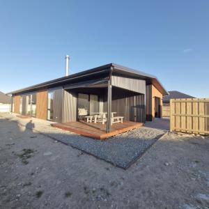 a small building with a porch and a deck at A newly built 3 bedroom home in Methven