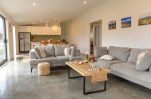 a living room with two couches and a table at A newly built 3 bedroom home in Methven