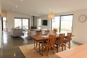 a dining room and living room with a table and chairs at A newly built 3 bedroom home in Methven