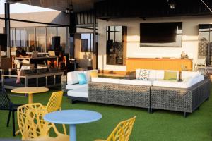 a living room with a couch and tables and chairs at 38 on Boulders Hotel in Gaborone