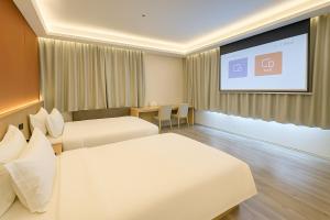 een hotelkamer met 2 bedden en een projectiescherm bij Bishkek Crystal Luxury Smart Hotel Ala-Too Square Branch in Bisjkek