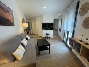 a living room with a couch and a flat screen tv at Apartamentos San Nicolas Jaca in Jaca