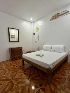 Un dormitorio con una cama grande con sábanas blancas. en Puerto Paraiso Hostel, en Puerto Princesa