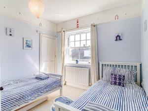 two beds in a room with a window at 3 bed property in Overstrand KT178 in Overstrand