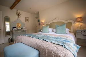 a bedroom with a large bed with blue pillows at The New White Lion in Llandovery