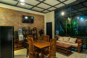 a dining room with a table and a couch at Bali Vanili Villa in Sukawati
